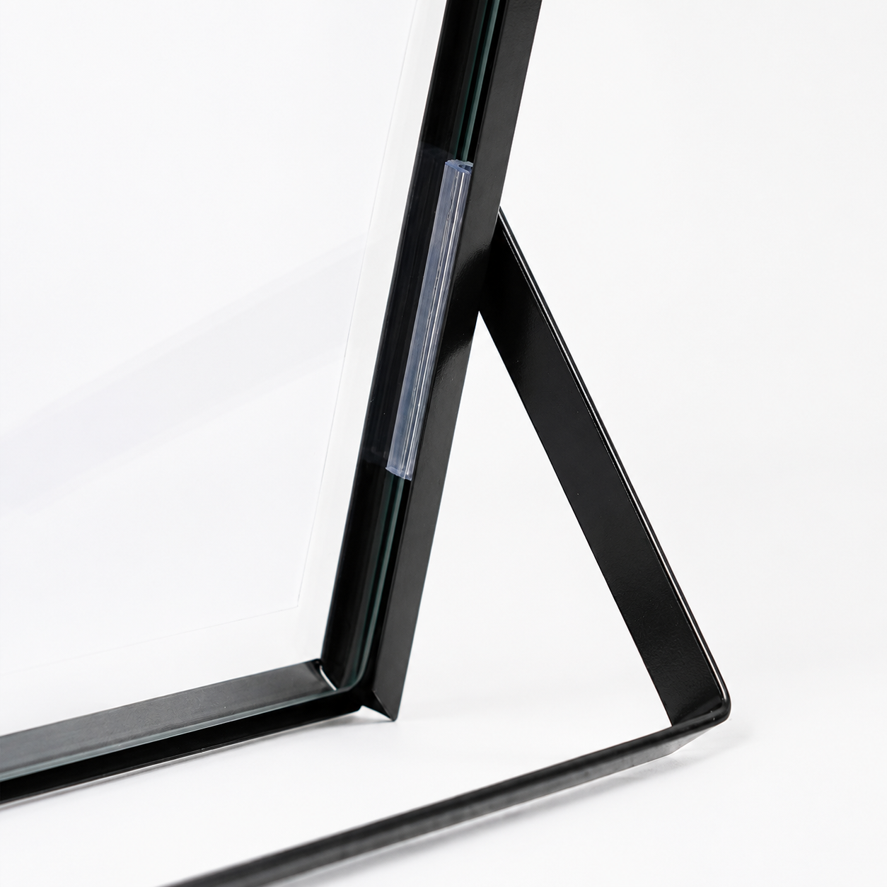 Close-up of black metal floating photo frame stand with glass panel edge