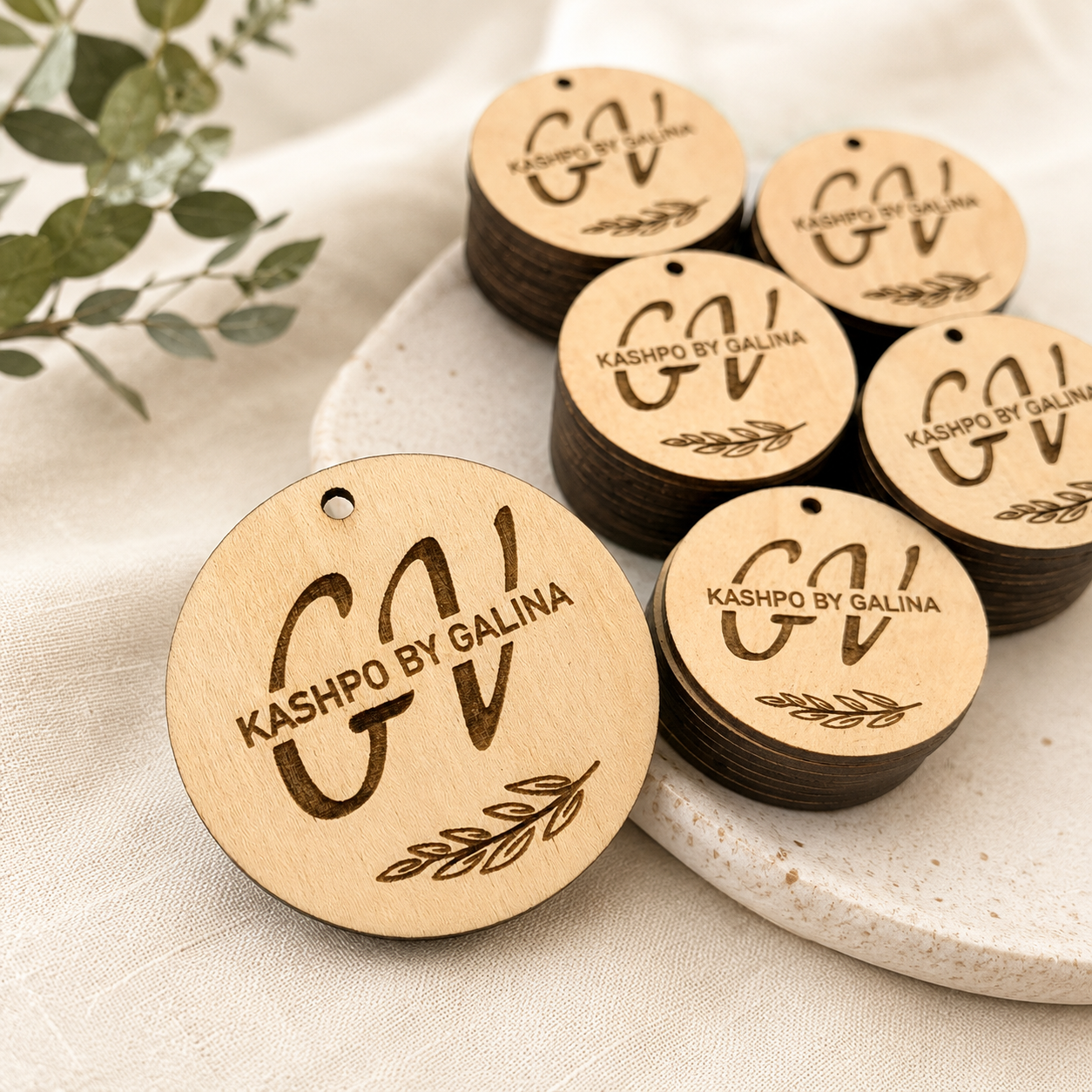 Custom laser-engraved round natural wood tags for handmade small business branding