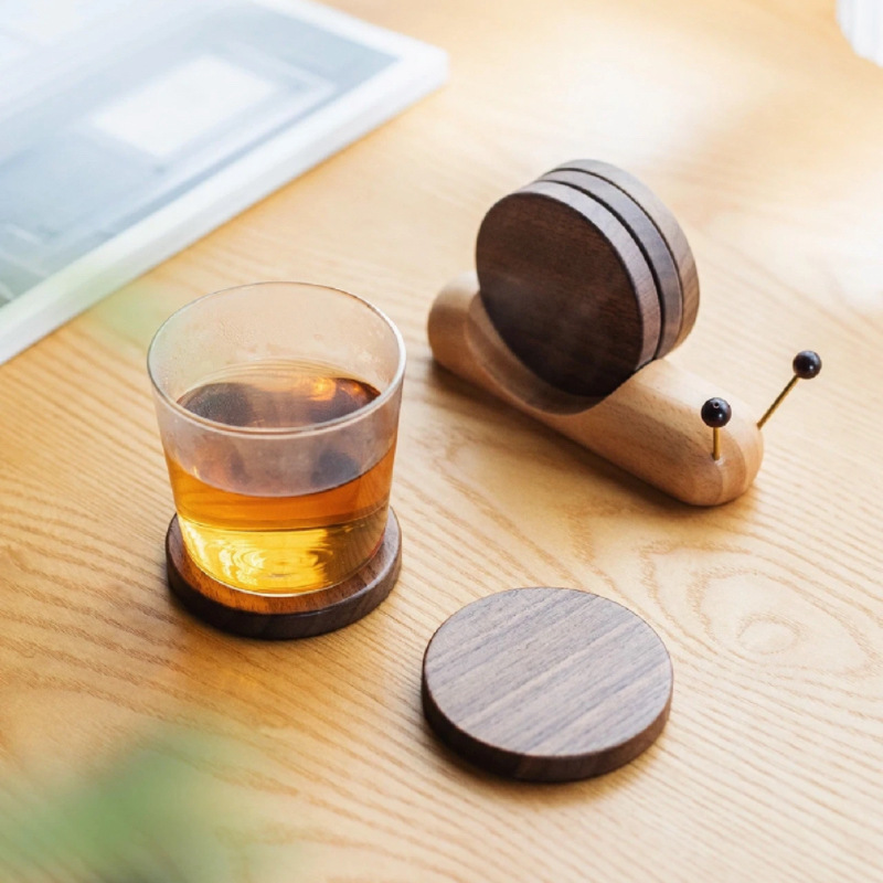 Personalized wooden snail coaster set with walnut coasters and a whiskey glass.