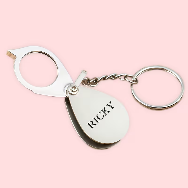 Personalized magnifying glass keychain, a folding silver gift engraved “RICKY.”